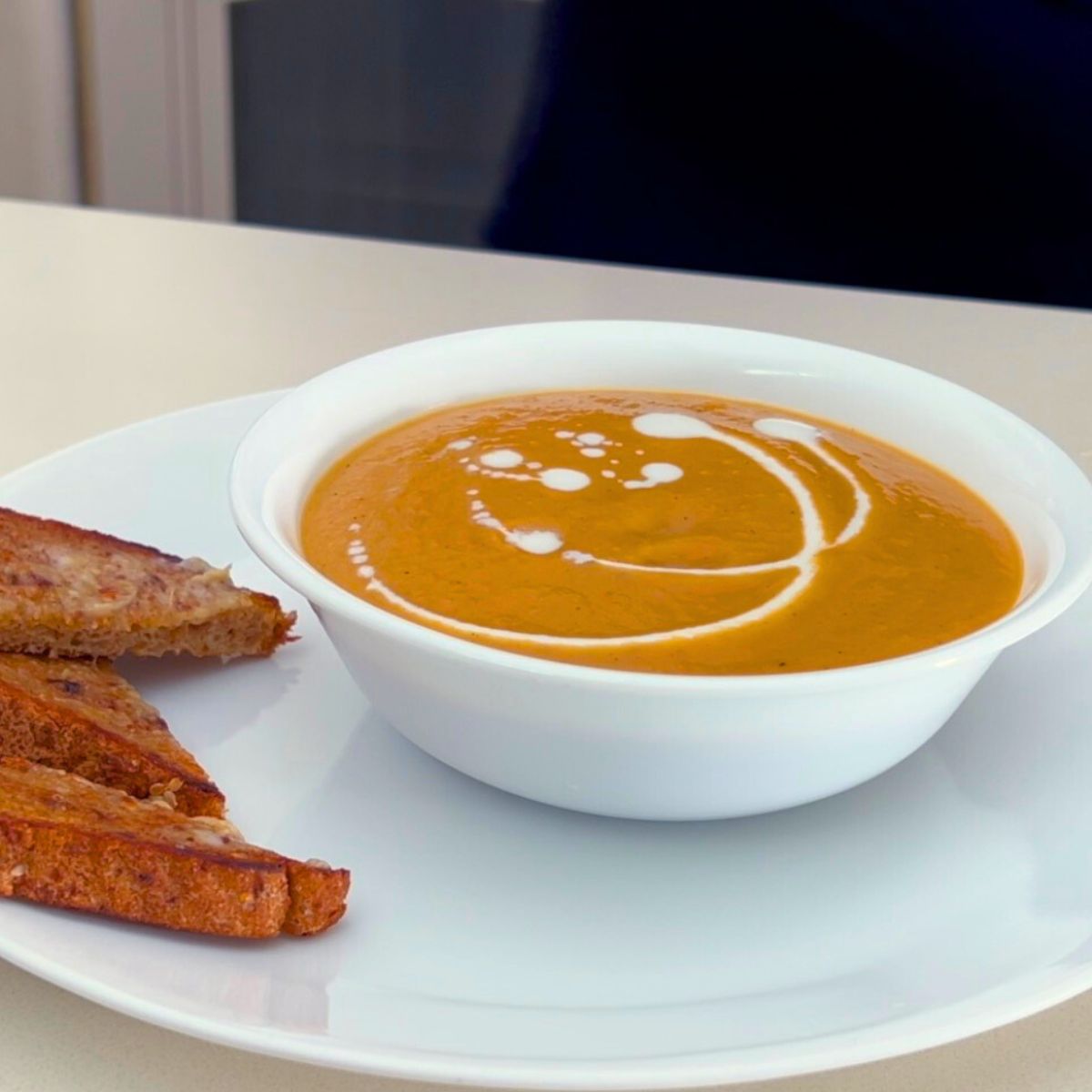Squash soup in a white bowl.