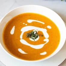 A white bowl with soup.