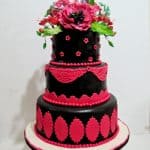 A Pink and Black fondant cake on the table.