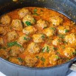 A pan with Indian curry and meatballs.
