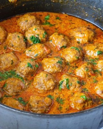 A pan with Indian curry and meatballs.