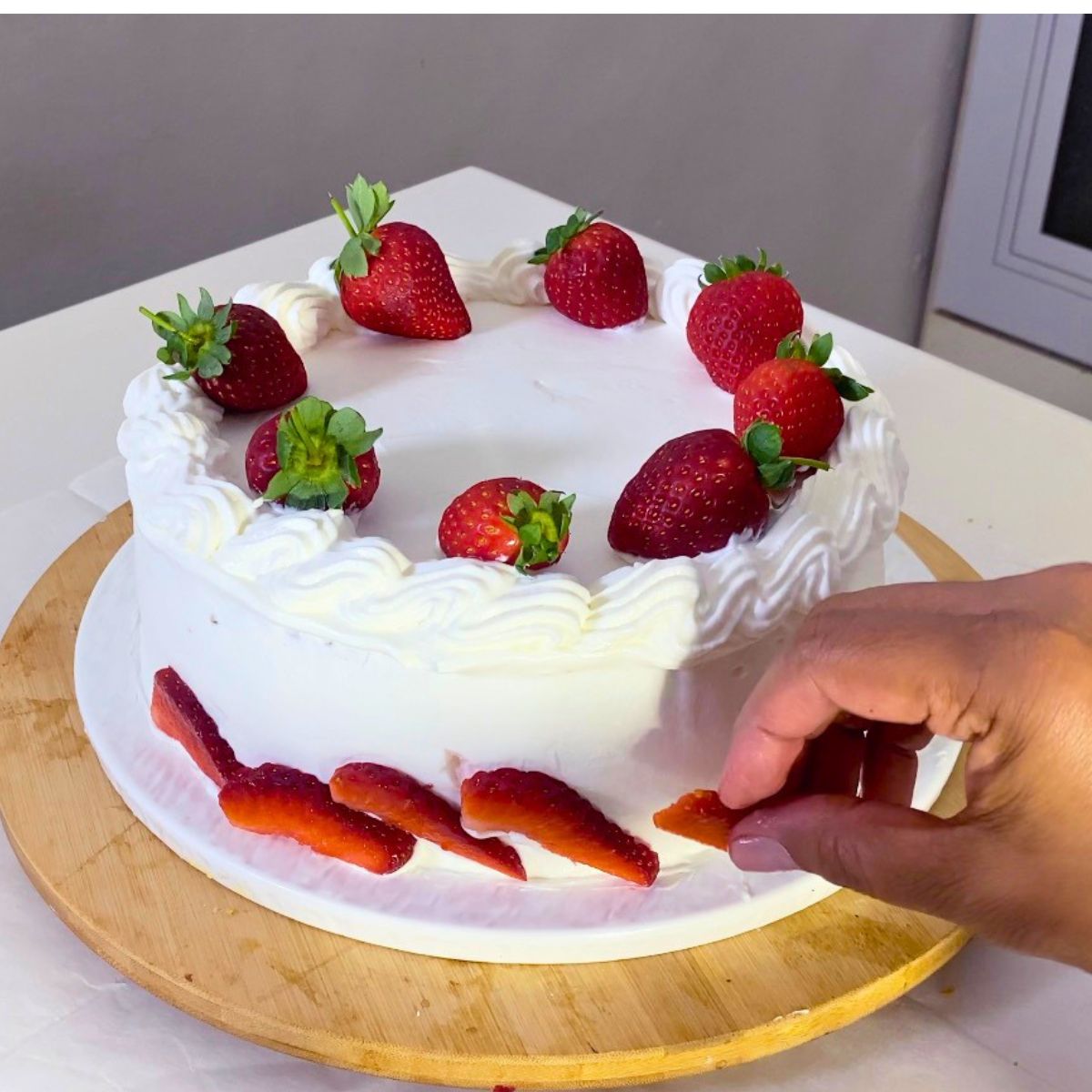 Progress pictures adding strawberries to the cake bottom.