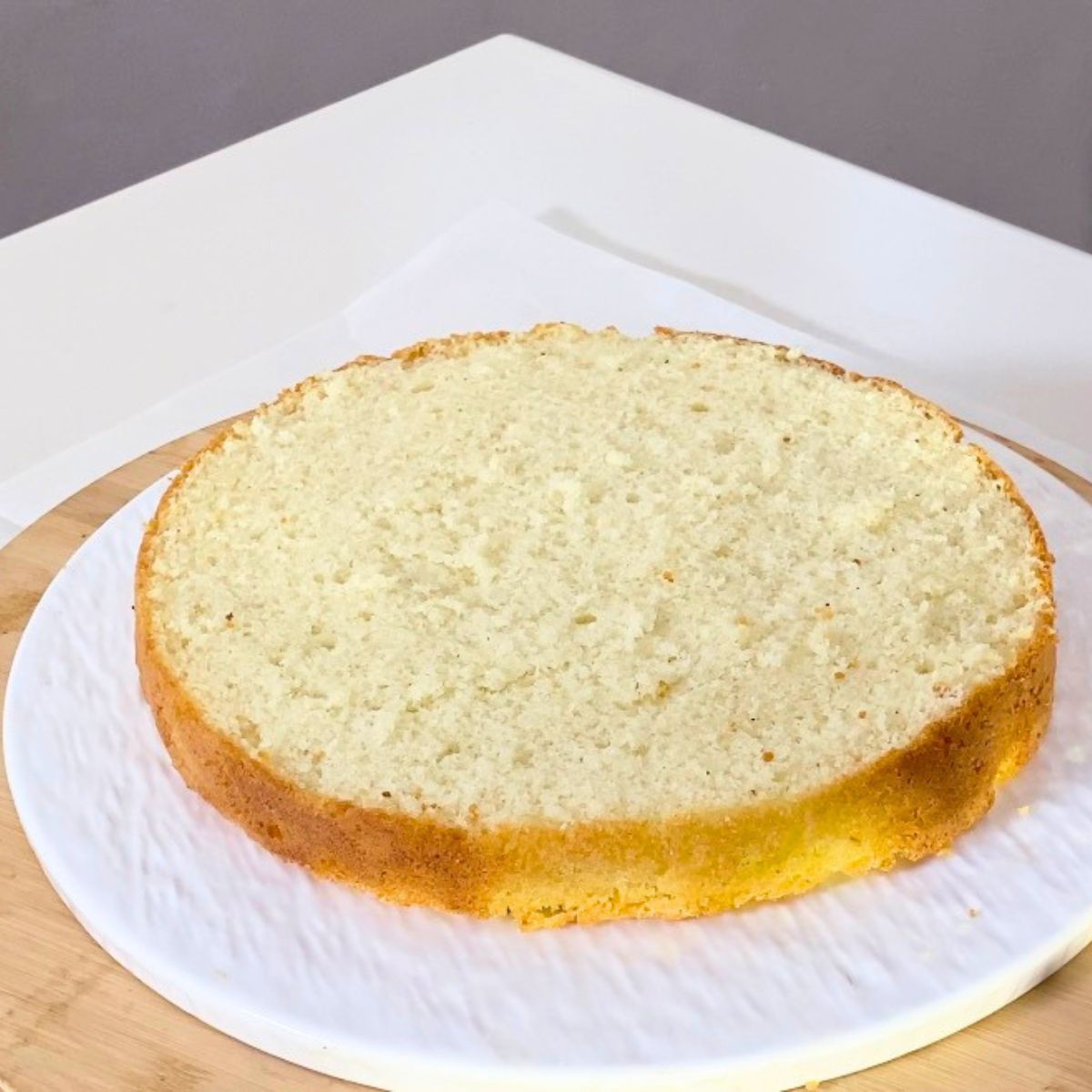 A layer of light sponge cake on the cake stand.