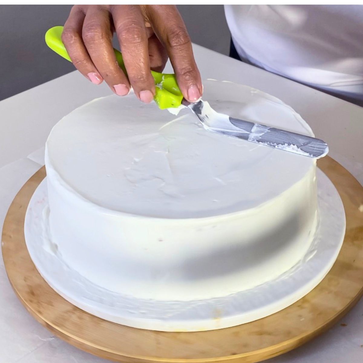 Frosting the cake with whipped cream.