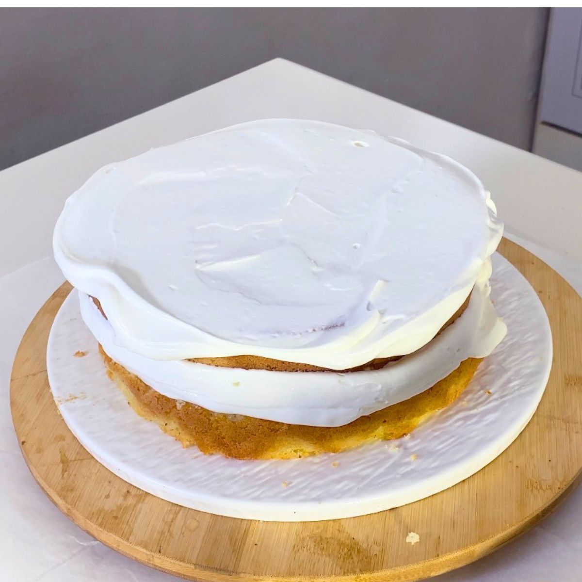 Frosting the cake with whipped cream.