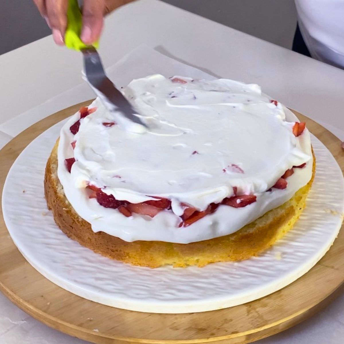 Layering the sponge cake with strawberries.