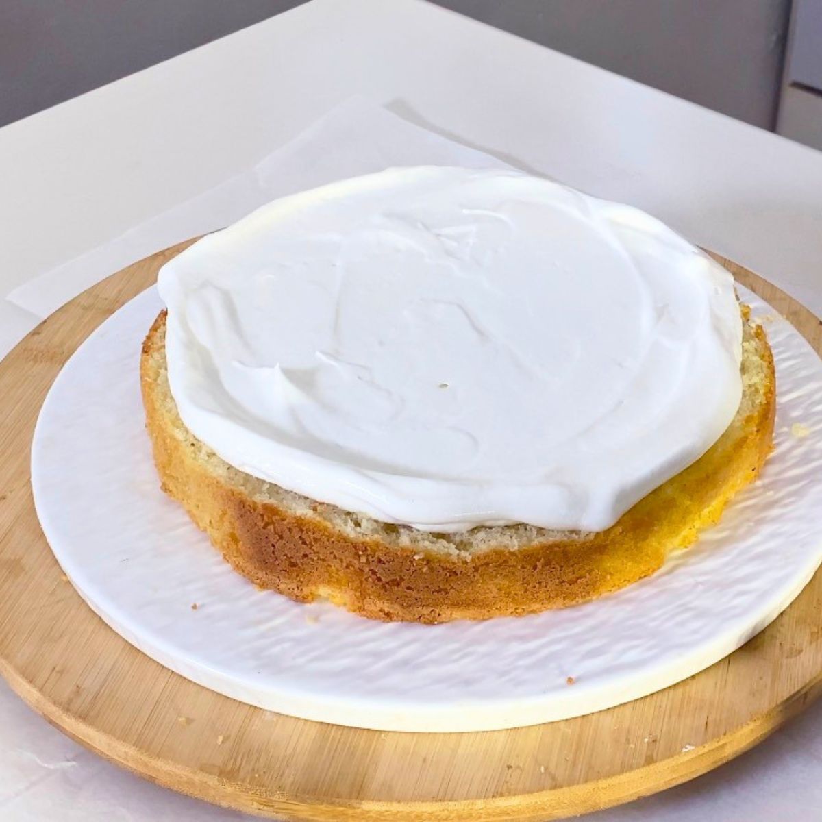Frosting a sponge cake with whipped cream.