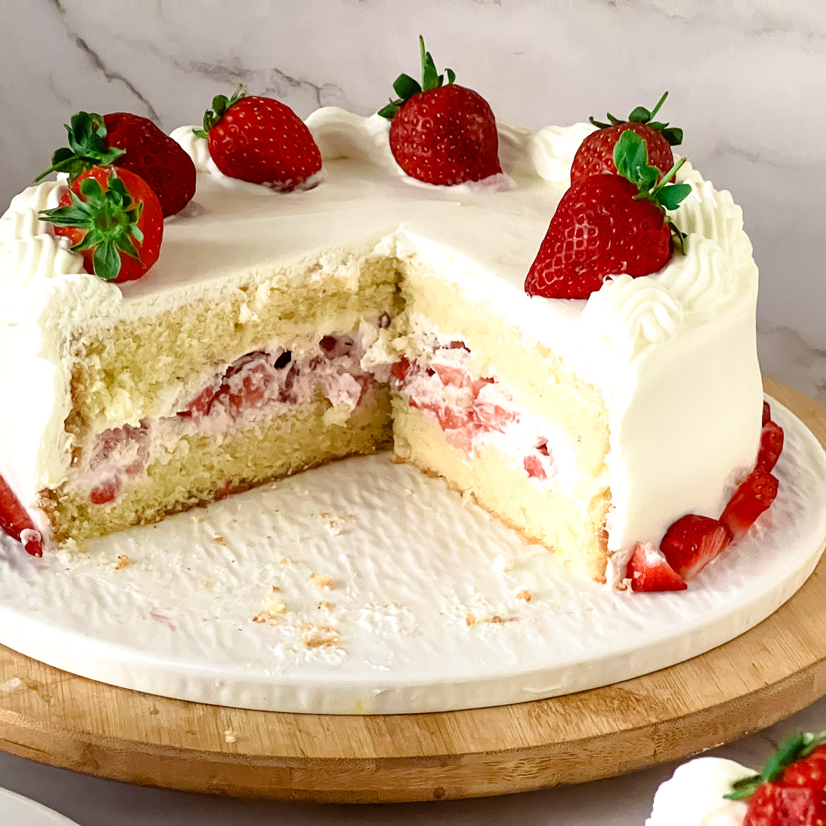 Sliced strawberry cream cake on the cake stand.