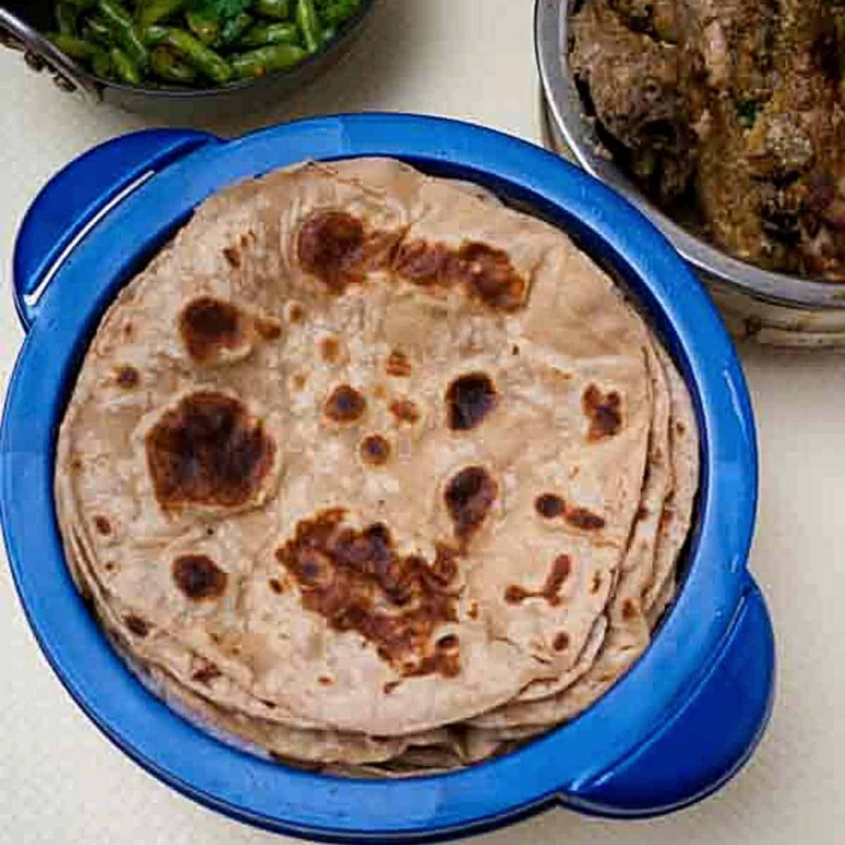 A tupperware with tortillas or chapati made with whole wheat flour.
