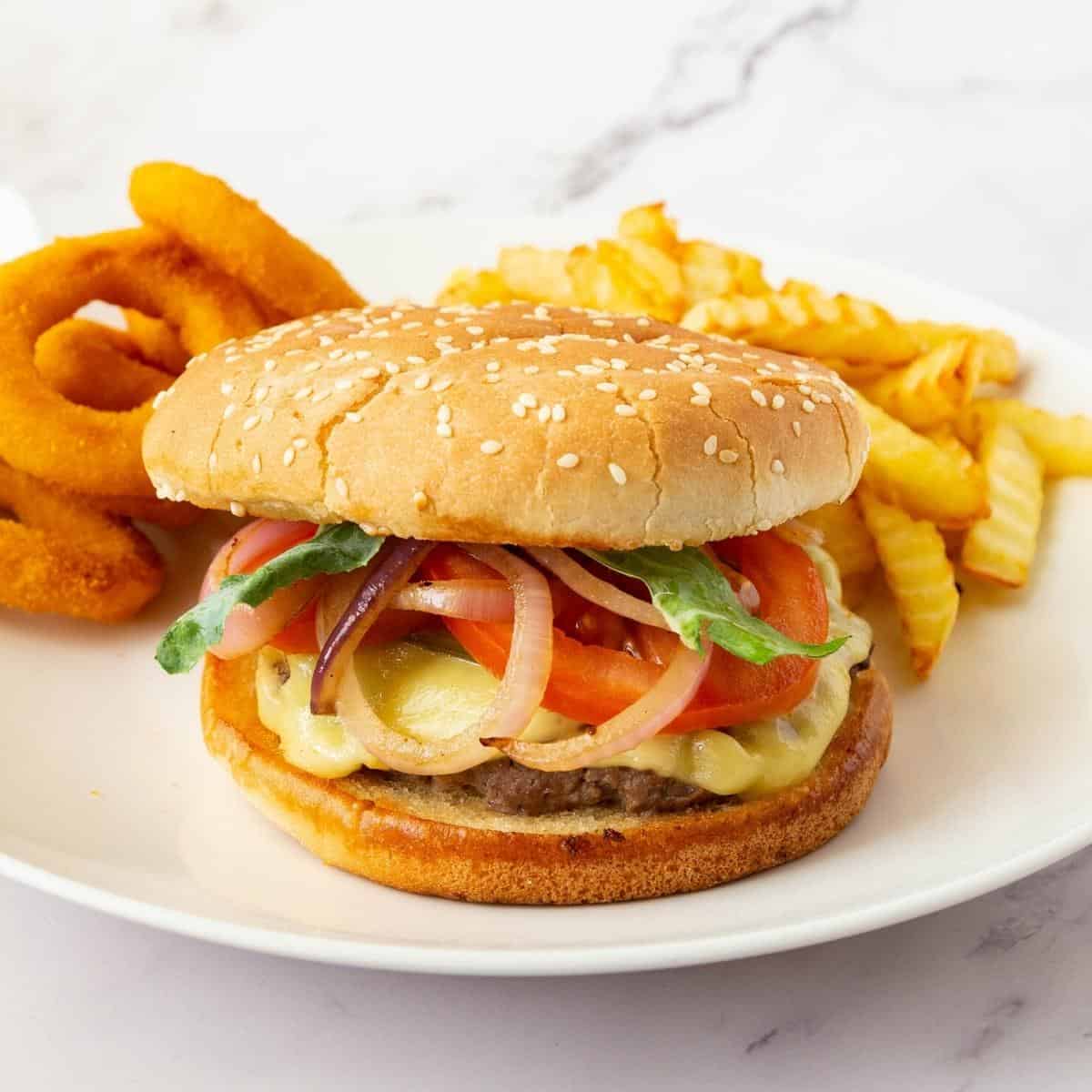 Burgers on a plate with fries and rings. 