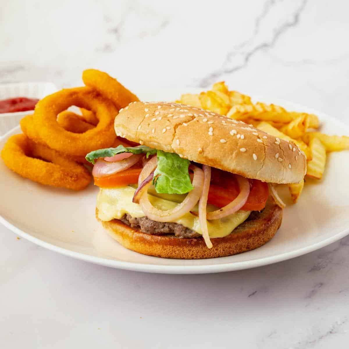 Burgers on a plate with fries and rings.