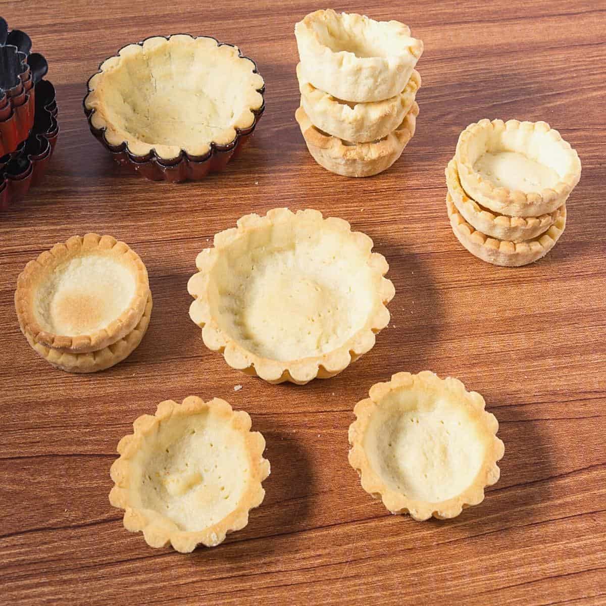 Pastry shells for mini tarts on a table.