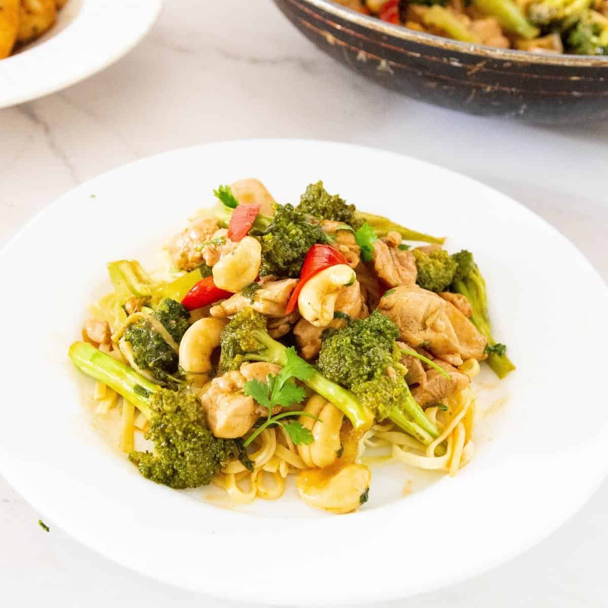 Chicken stir fry with broccoli over boiled noodles.
