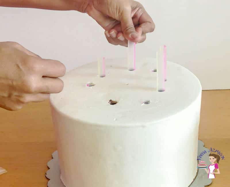 A person doweling a cake.