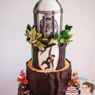 A cake decorated to look like a chimpanzee on a tree.