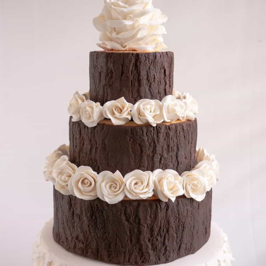 A three tier cake covered with modeling chocolate.