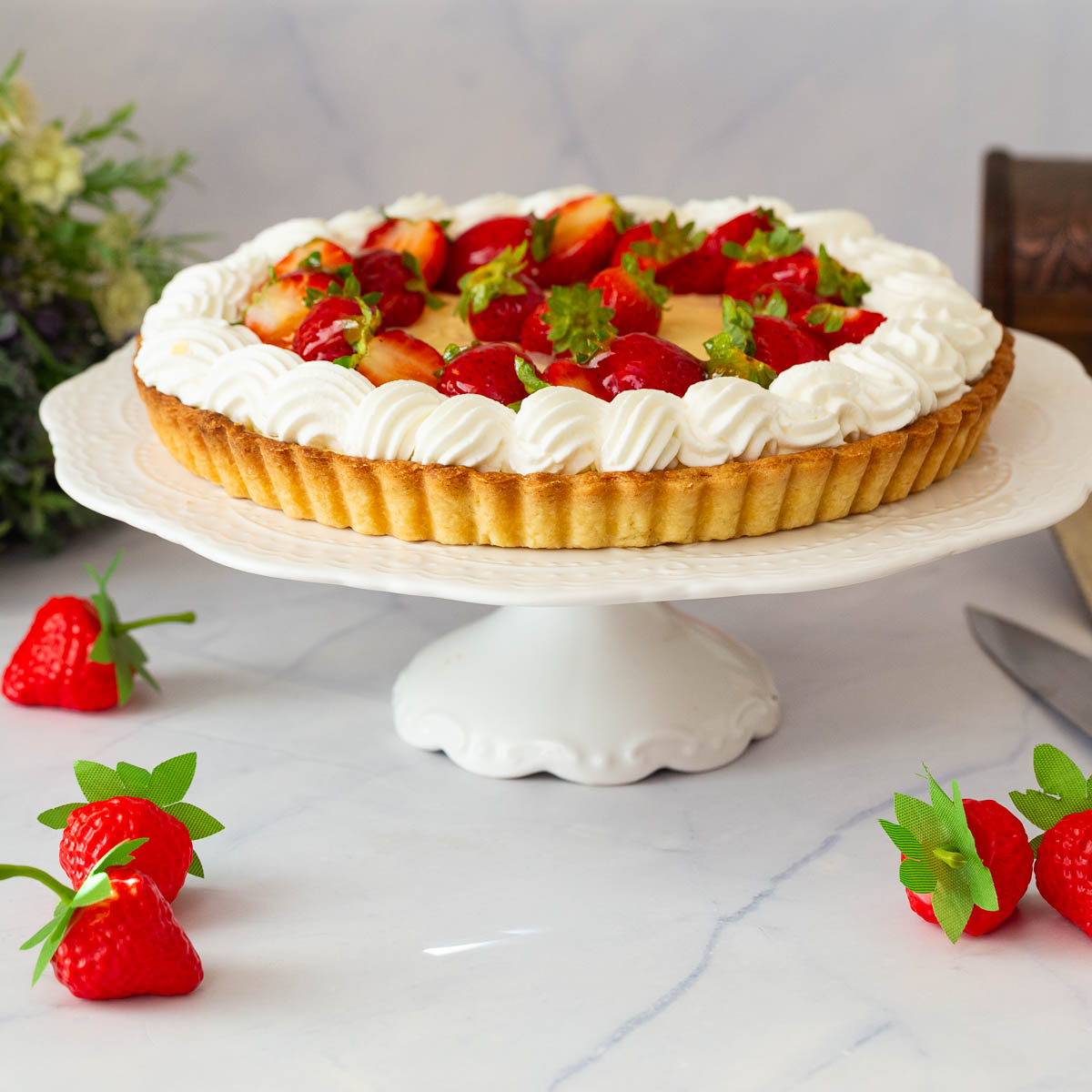A pastry cream tart on the cake stand.