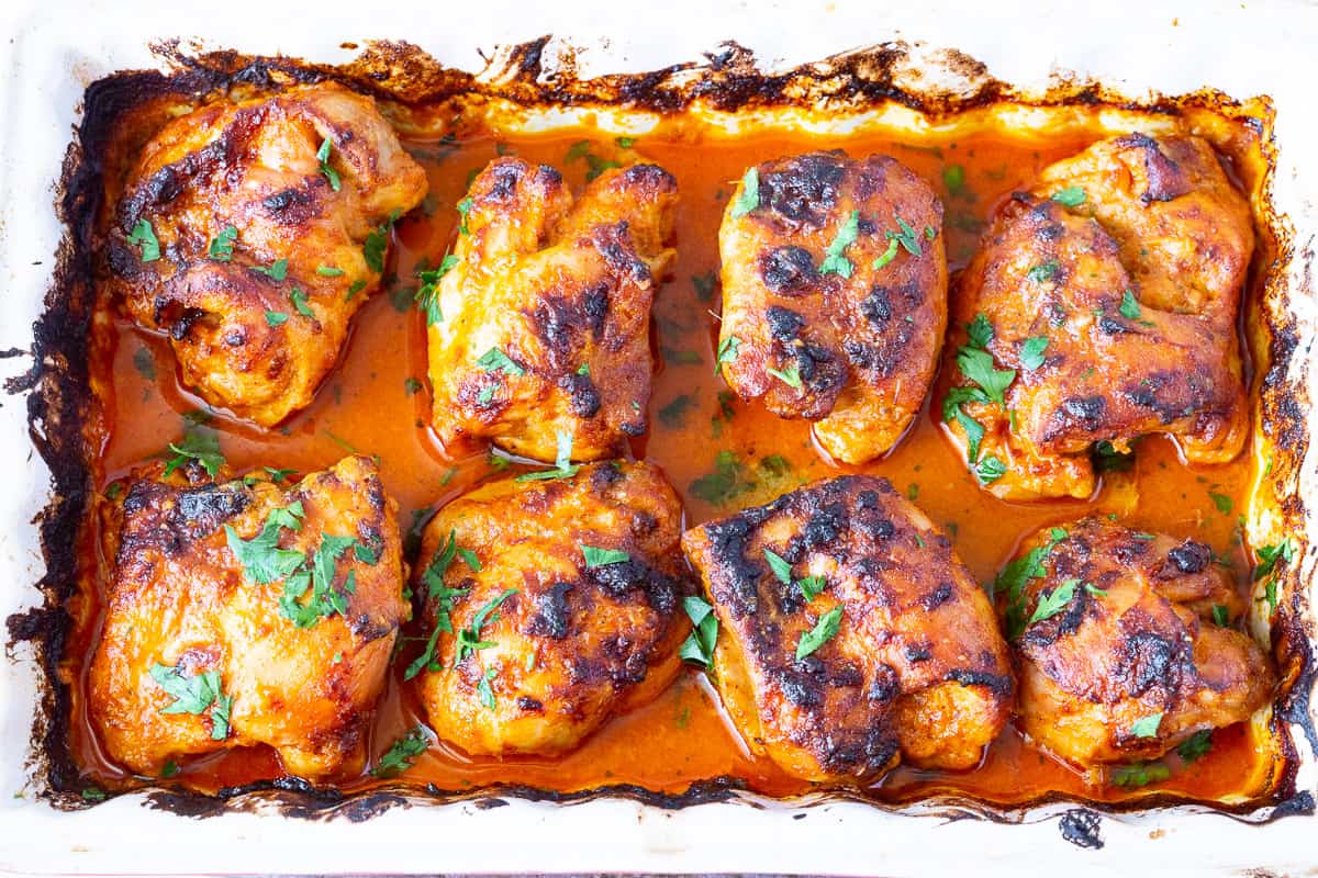 A baking dish with curried chicken thighs.