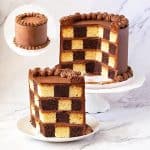A layer cake with checkerboard effect on the table.
