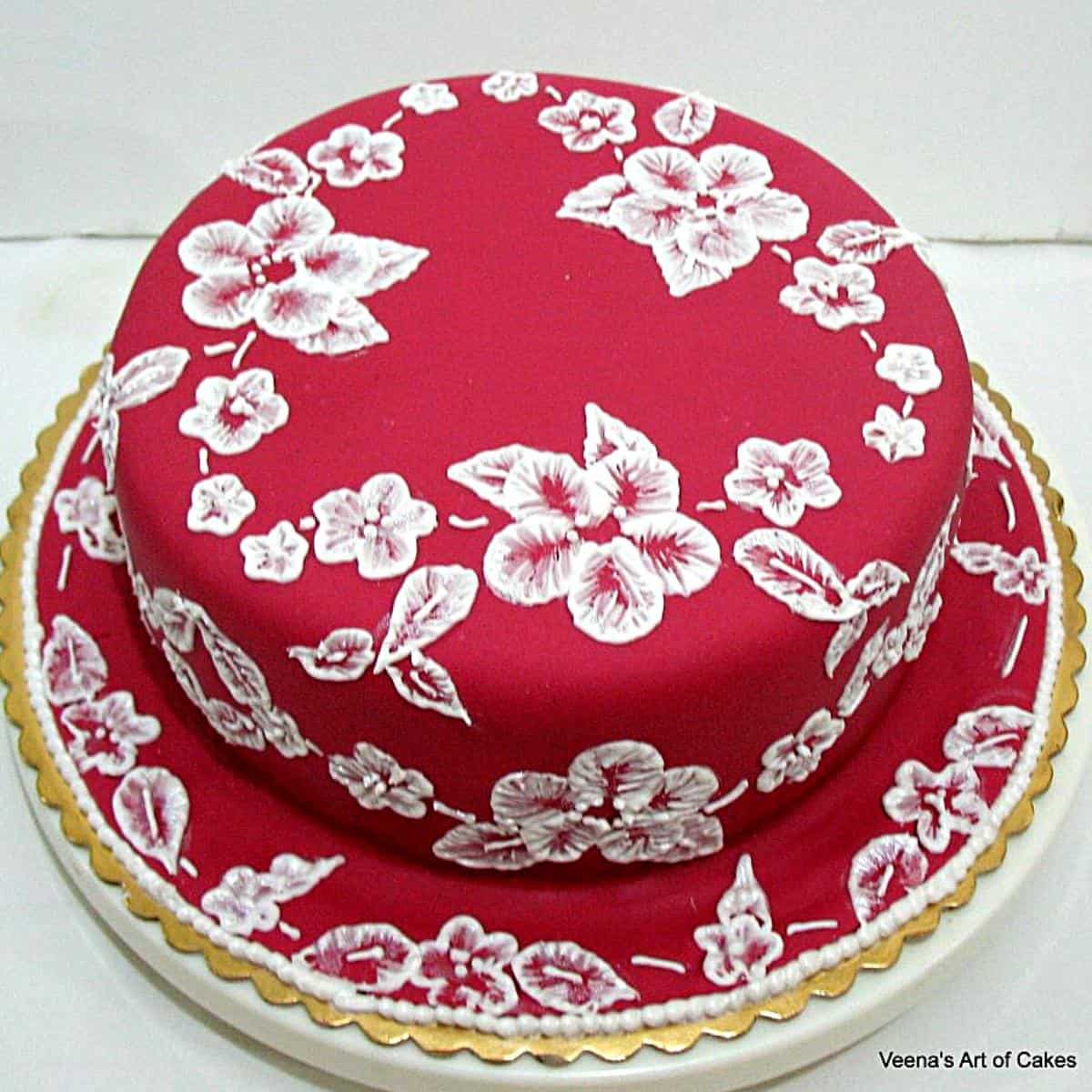 A red velvet cake with lace piping.