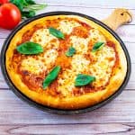 A pizza sitting on top of a wooden board.