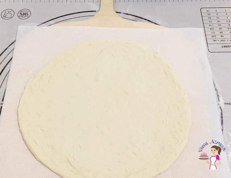 Rolled pizza dough on a pizza peel.