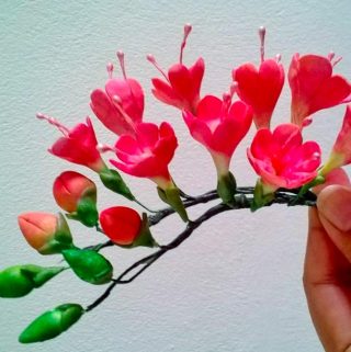 A person holding a sugar flower.