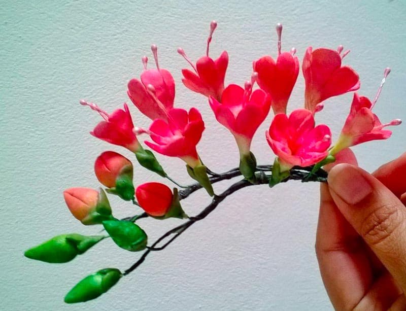 A person holding a sugar flower.
