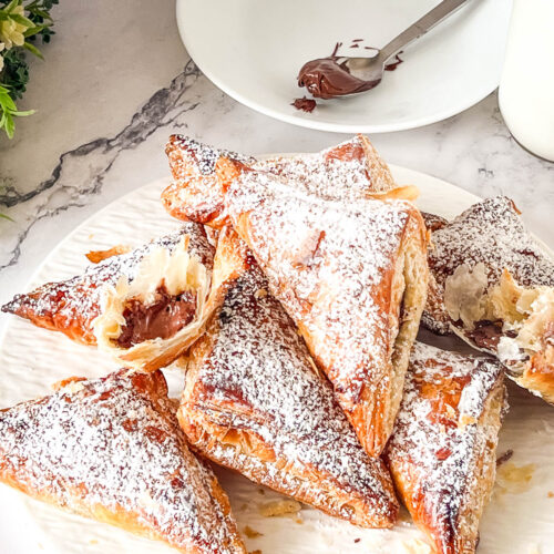 Puff pastry nutella bites dusted with powdered sugar.