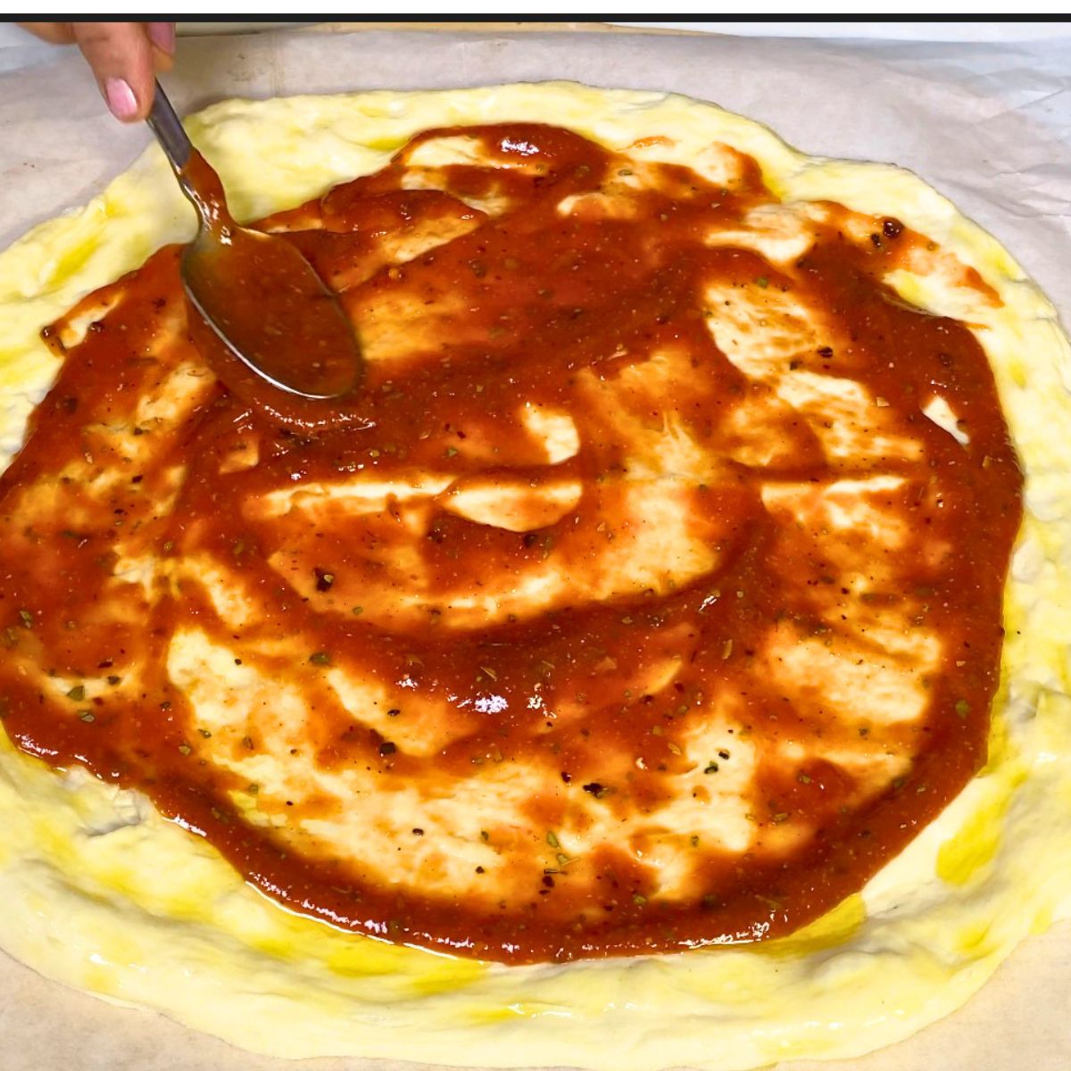 Spread the pizza with pizza sauce.