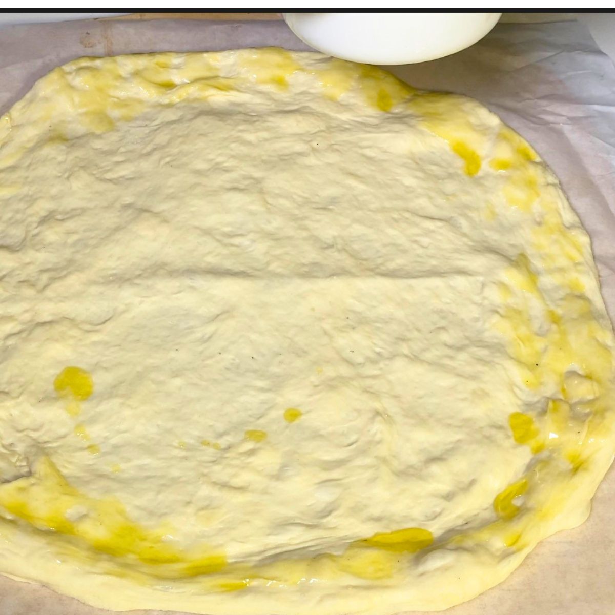 Brush pizza dough edges with olive oil for crisp crust.
