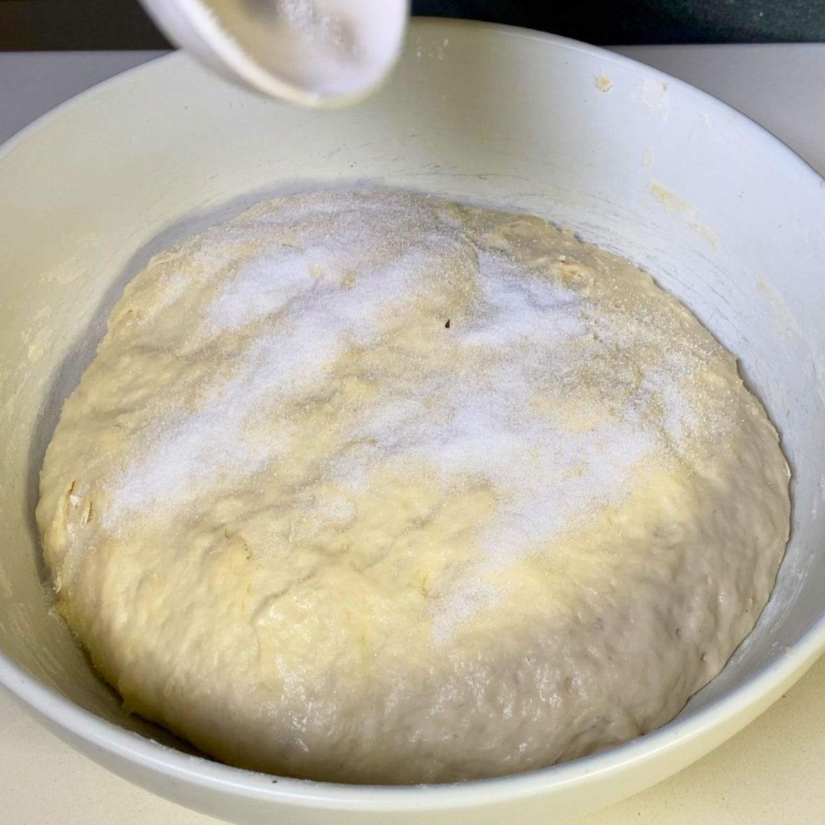 Adding salt to the pizza dough preparation.