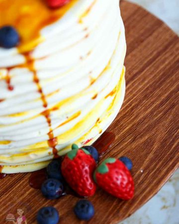 A close up of a cake decorated to look like a stack of pancakes.