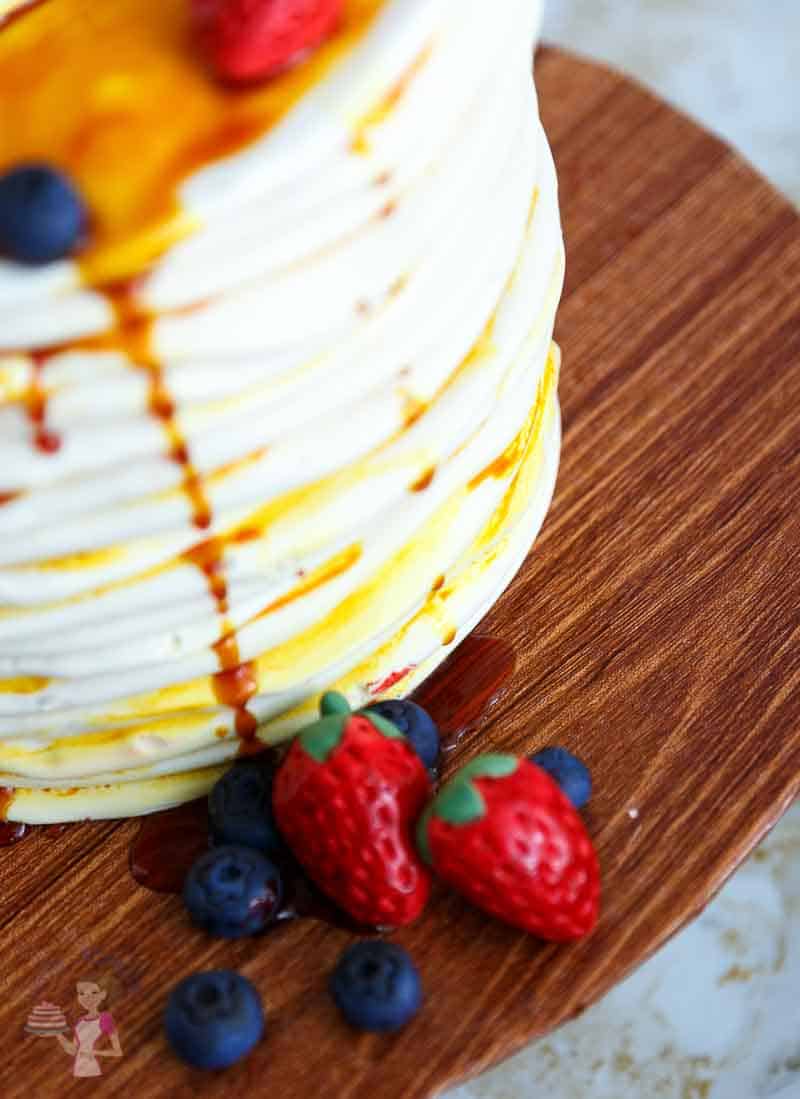 A close up of a cake decorated to look like a stack of pancakes.