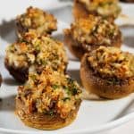 A plate with breadcrumb stuffed mushrooms.