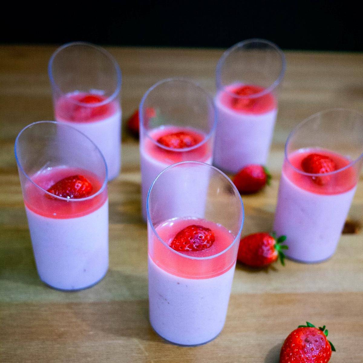 Dessert cups with bavarian cream topped with strawberries.
