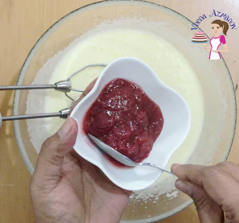 A person making the mixture for strawberry cupcakes.