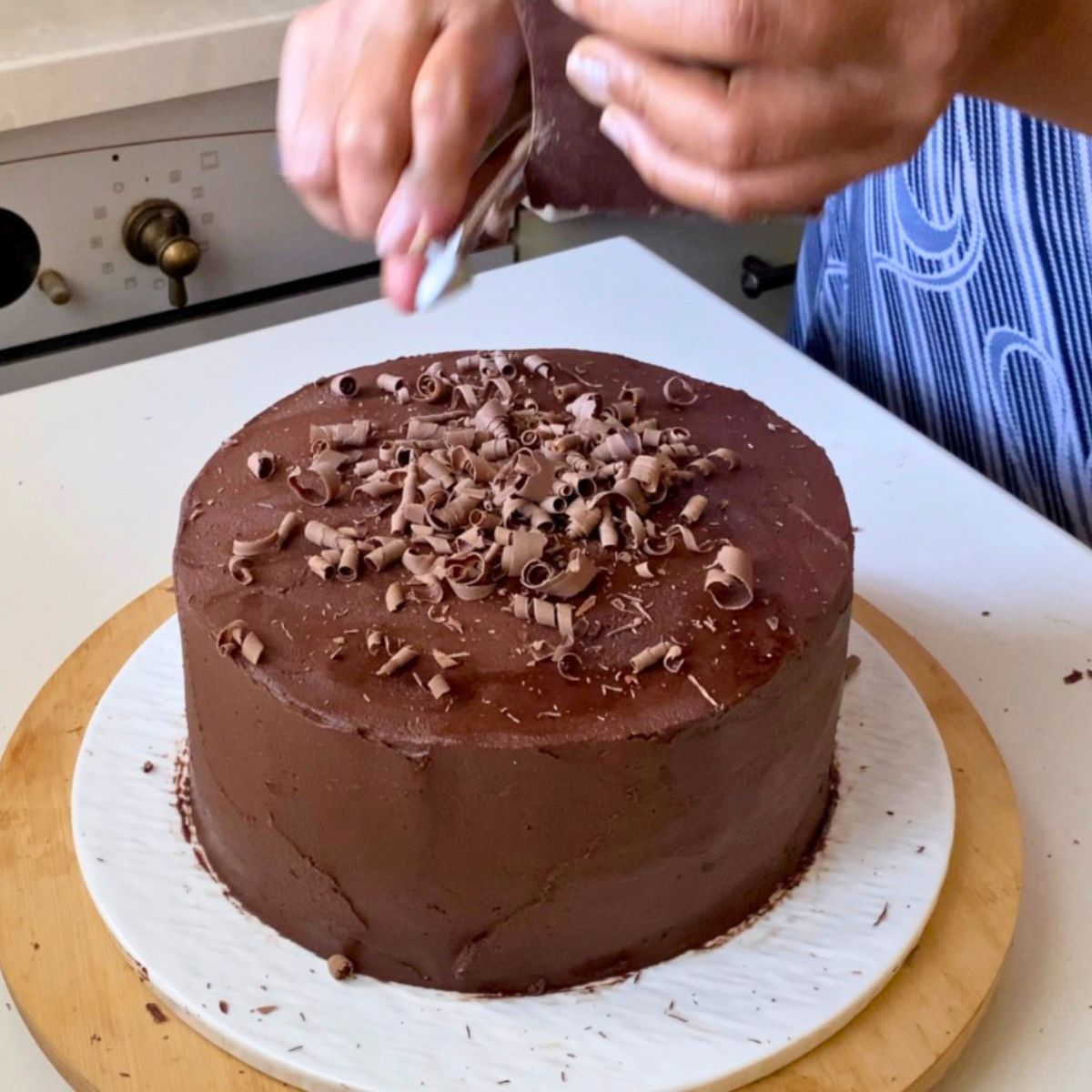 Peeling chocolate bar on the chocolate cake.