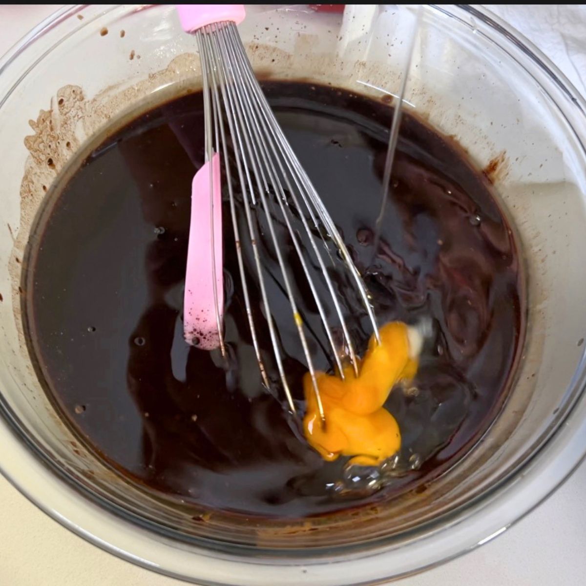 Adding the eggs to the chocolate batter.