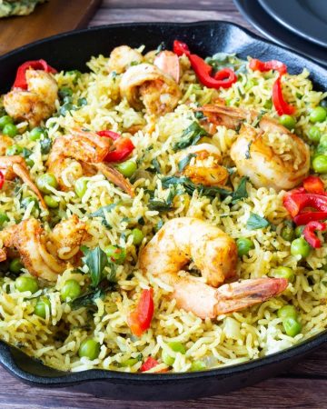 Skillet with cooked rice and prawns.