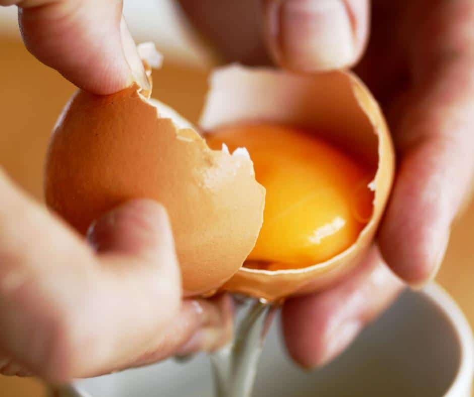 A person breaking open an egg.