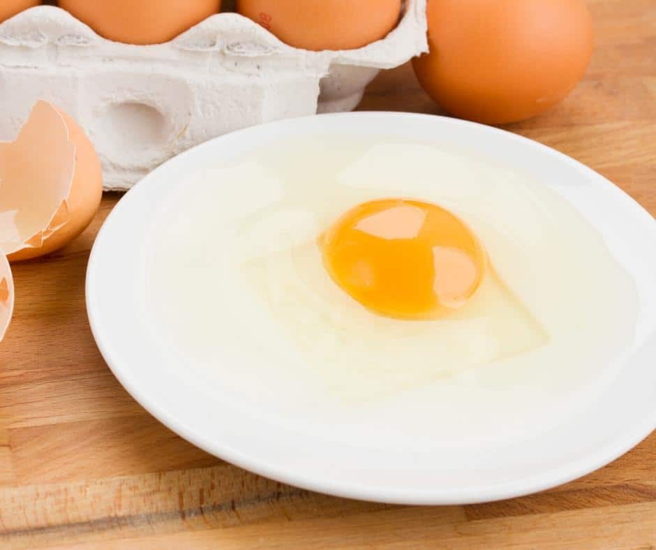 A raw egg on a plate.