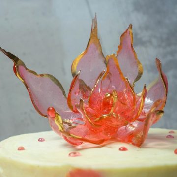 An isomalt flower on a cake.