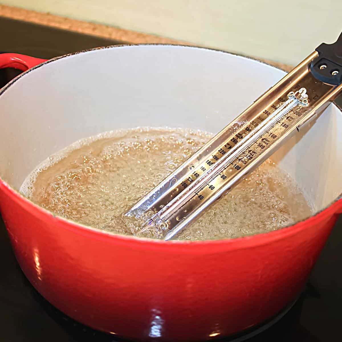 A pan with cooking isomalt and candy thermometer.