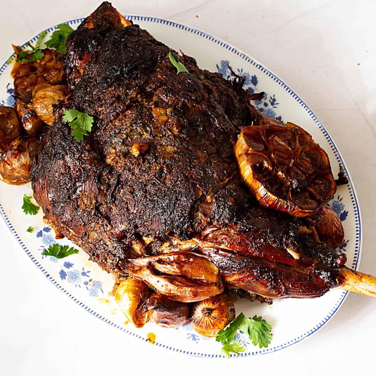 A large platter with slow roasted leg of lamb