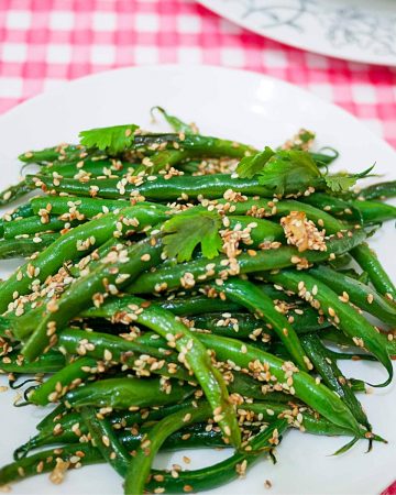 A plate with green beans and sesame seeds.