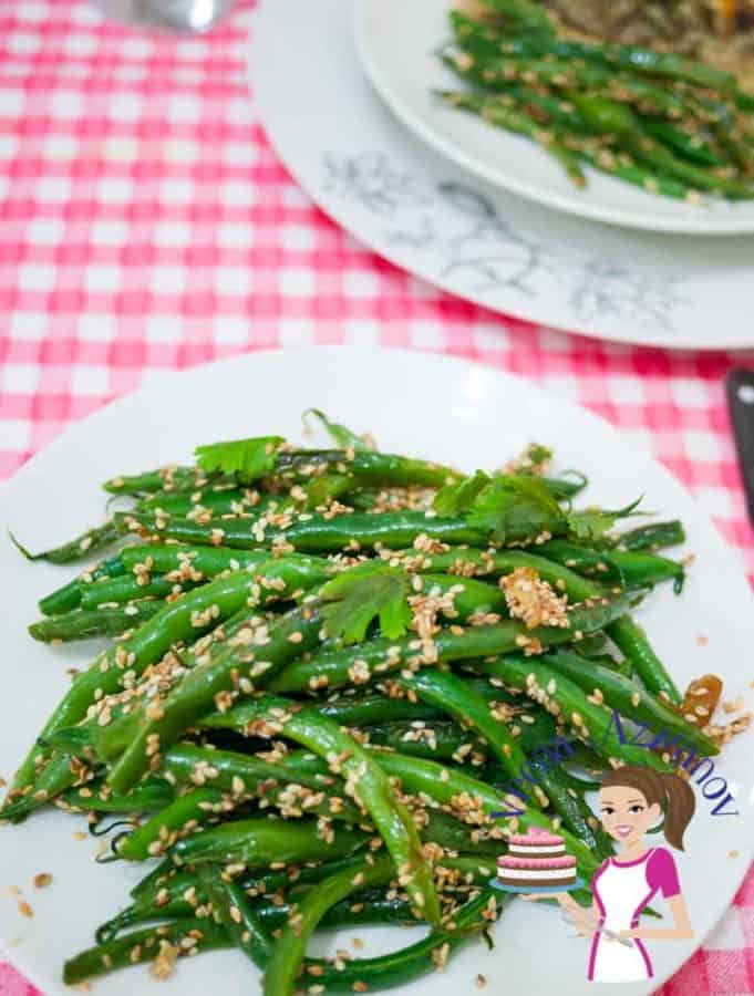 A plate of green beans with sesame seeds.