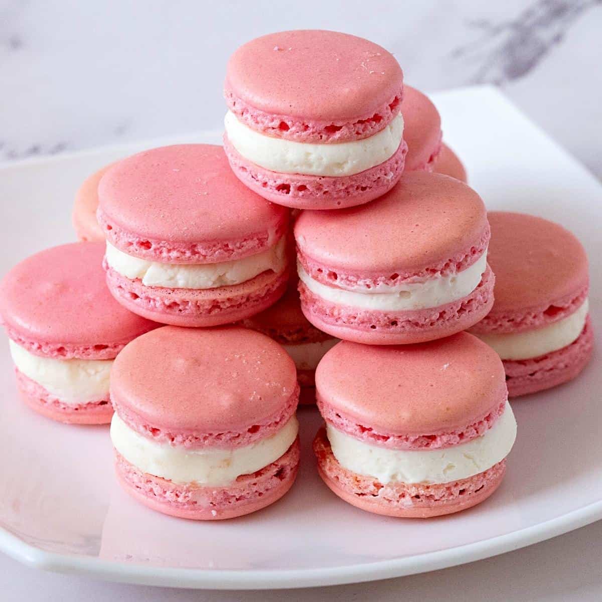 A stack of pink macarons filling with strawberry filling.