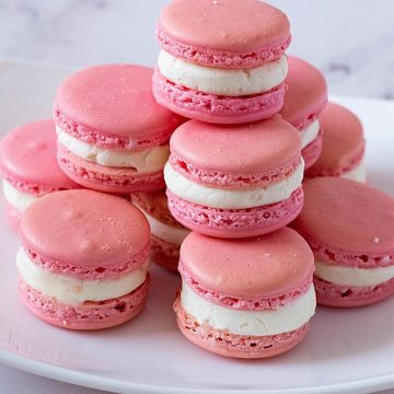A white plate with Strawberry French macarons.