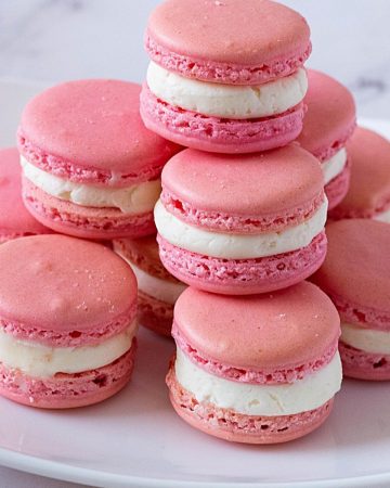 A white plate with Strawberry French macarons.